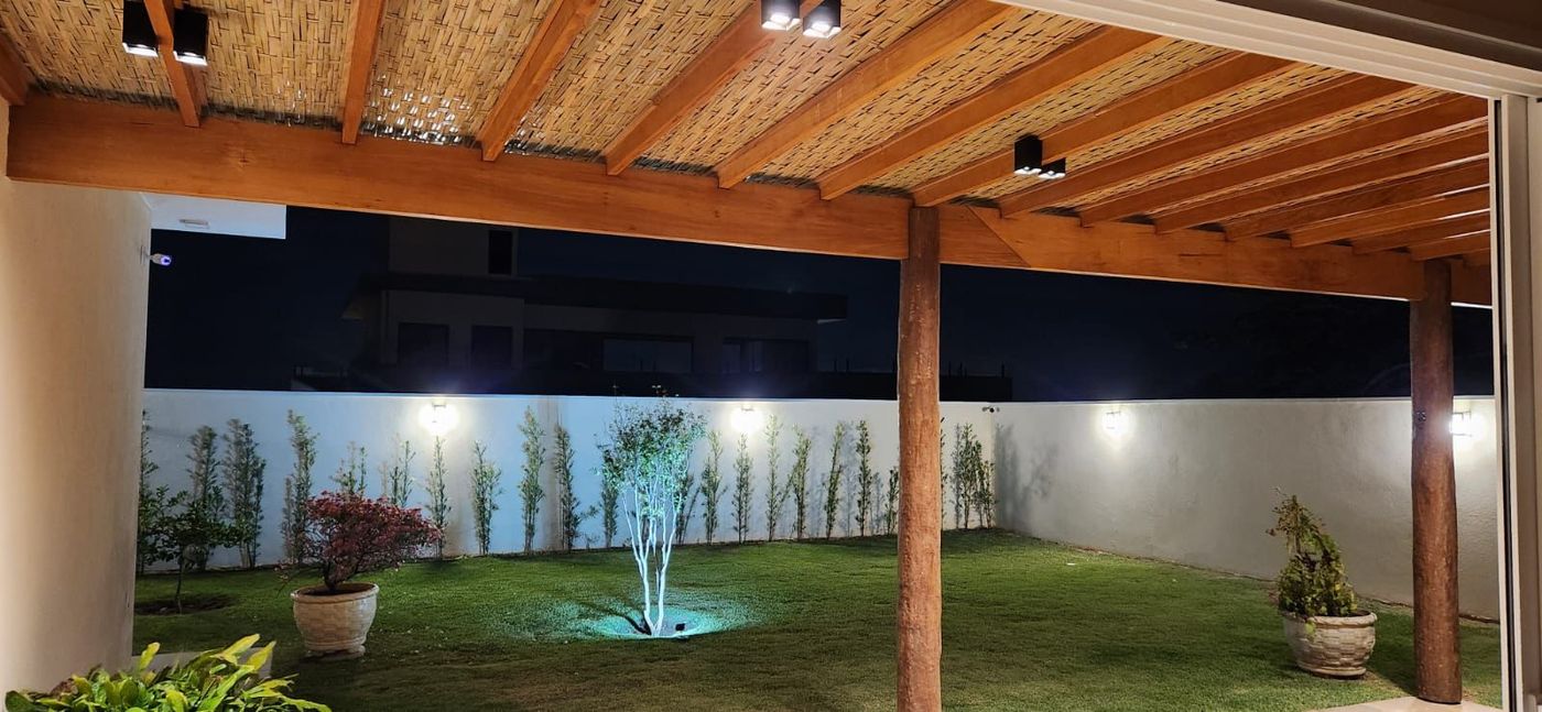 Pergolado em bambu natural iluminado à noite