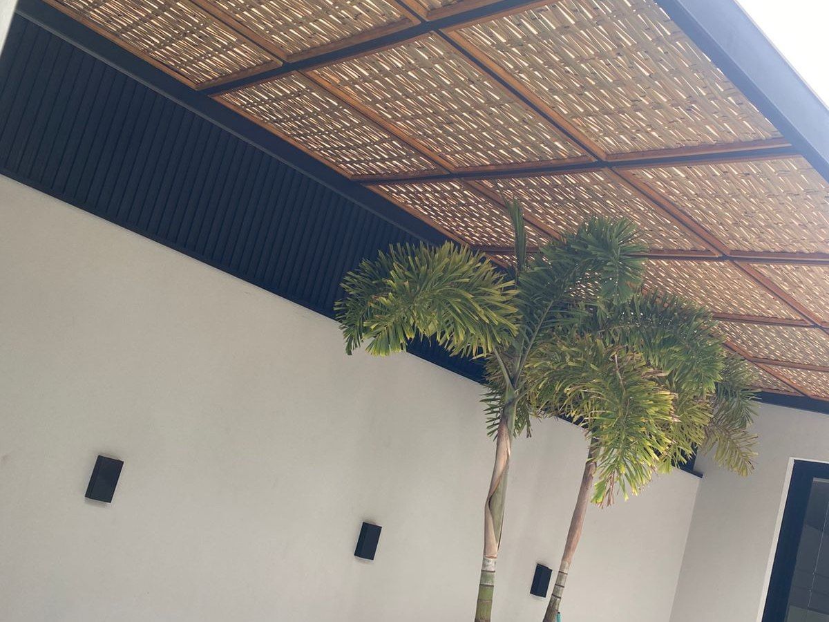 Área de piscina coberta com pergolado em bambu natural
